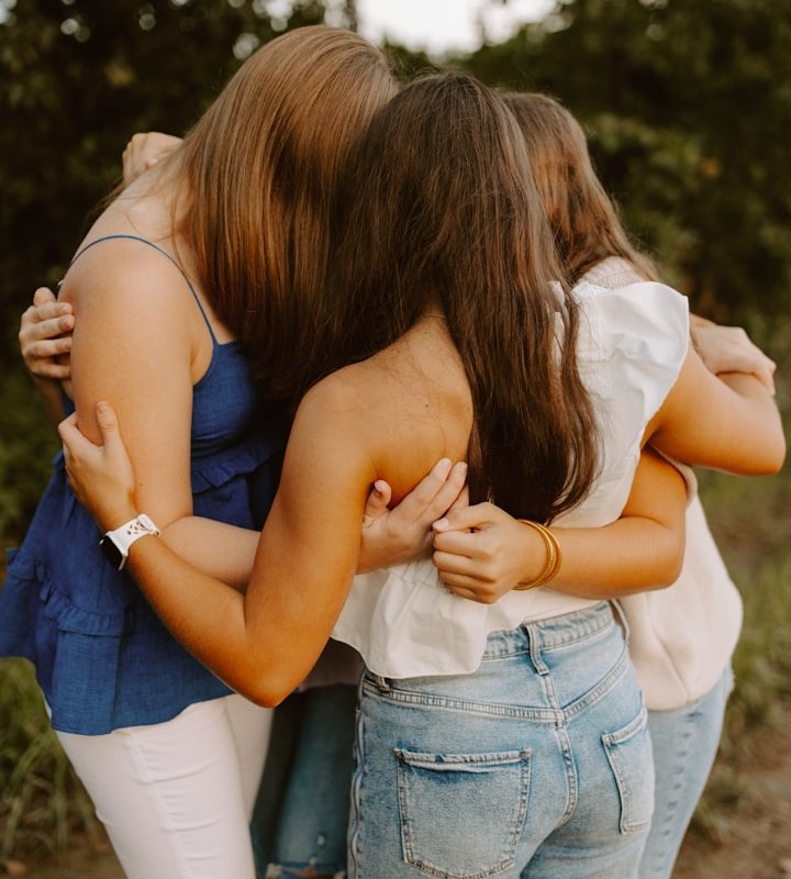 A group of young women hugging each other